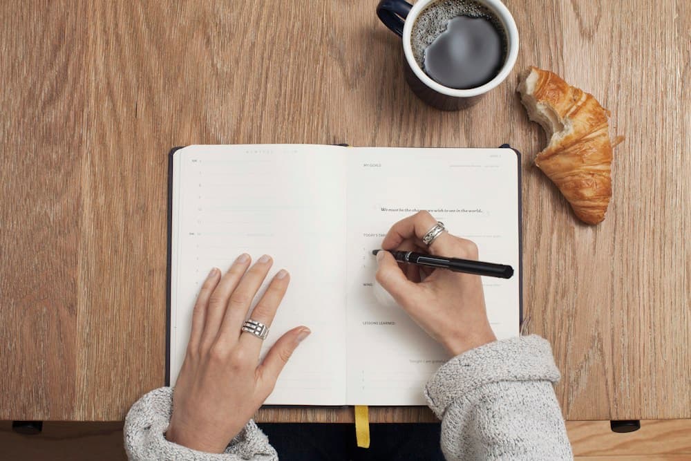A learner writing goals and reflections in an open notebook